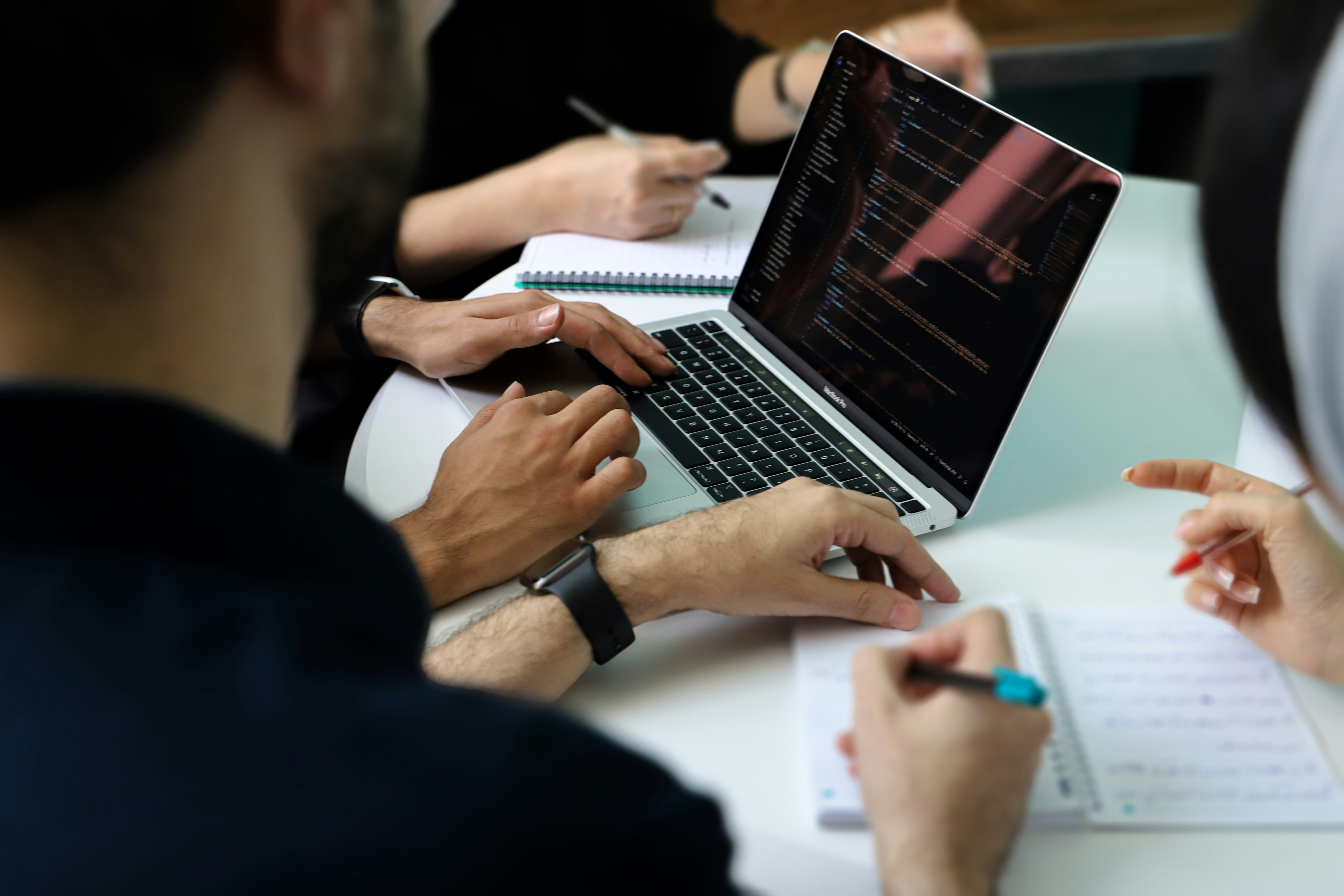 Gruppo di persone sedute a un tavolo con un laptop