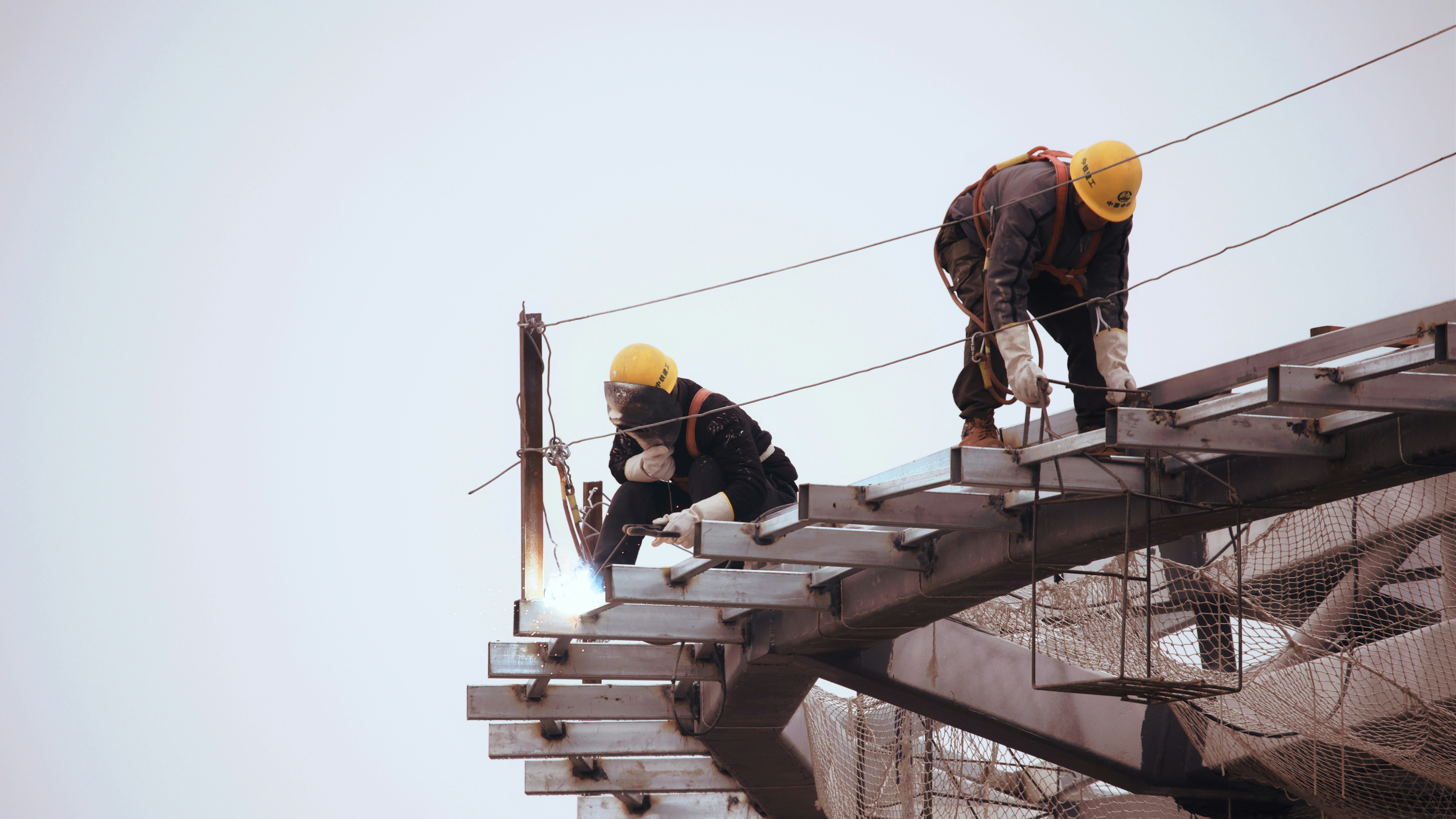 Un uomo con un giacchetto nero e un elmetto giallo in un cantiere edile